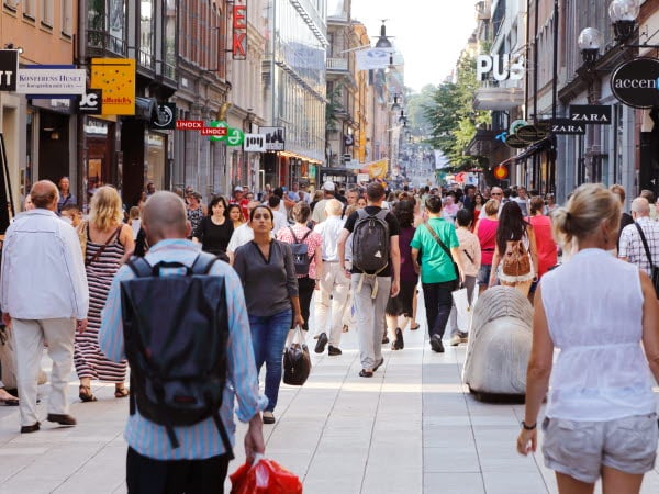 Sommardag på gågatan Drottninggatan mellan Mäster Samuelsgatan och Kungsgatan i Stockholm, Sverige, med folk i rörelse.